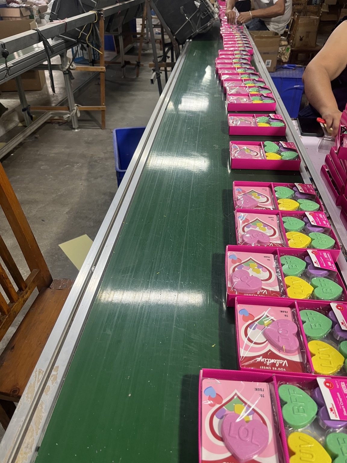 Heart-shaped crayon sets being packed along a conveyor
