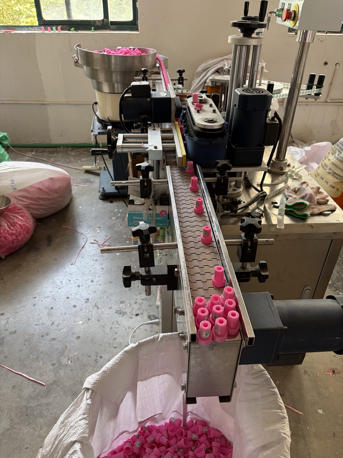 Pink stamp components moving through the labeling machine